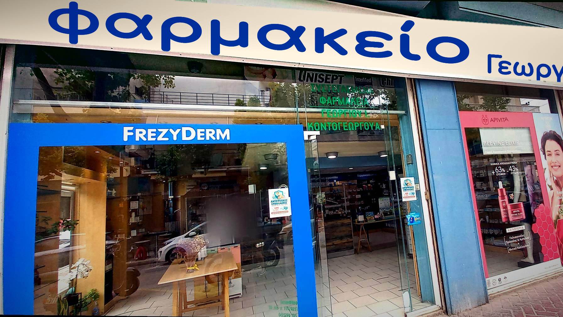 Η πρόσοψη του Φαρμακείου Γεωργίου στον Κορυδαλλό, με την πινακίδα «Φαρμακείο Γεωργίου» και τη μπλε βιτρίνα.